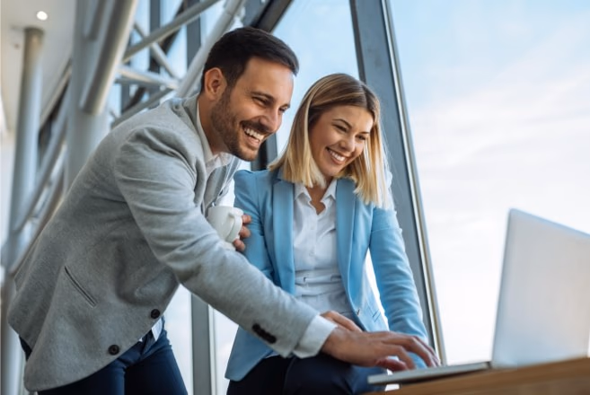 A man and a woman looking at a laptop